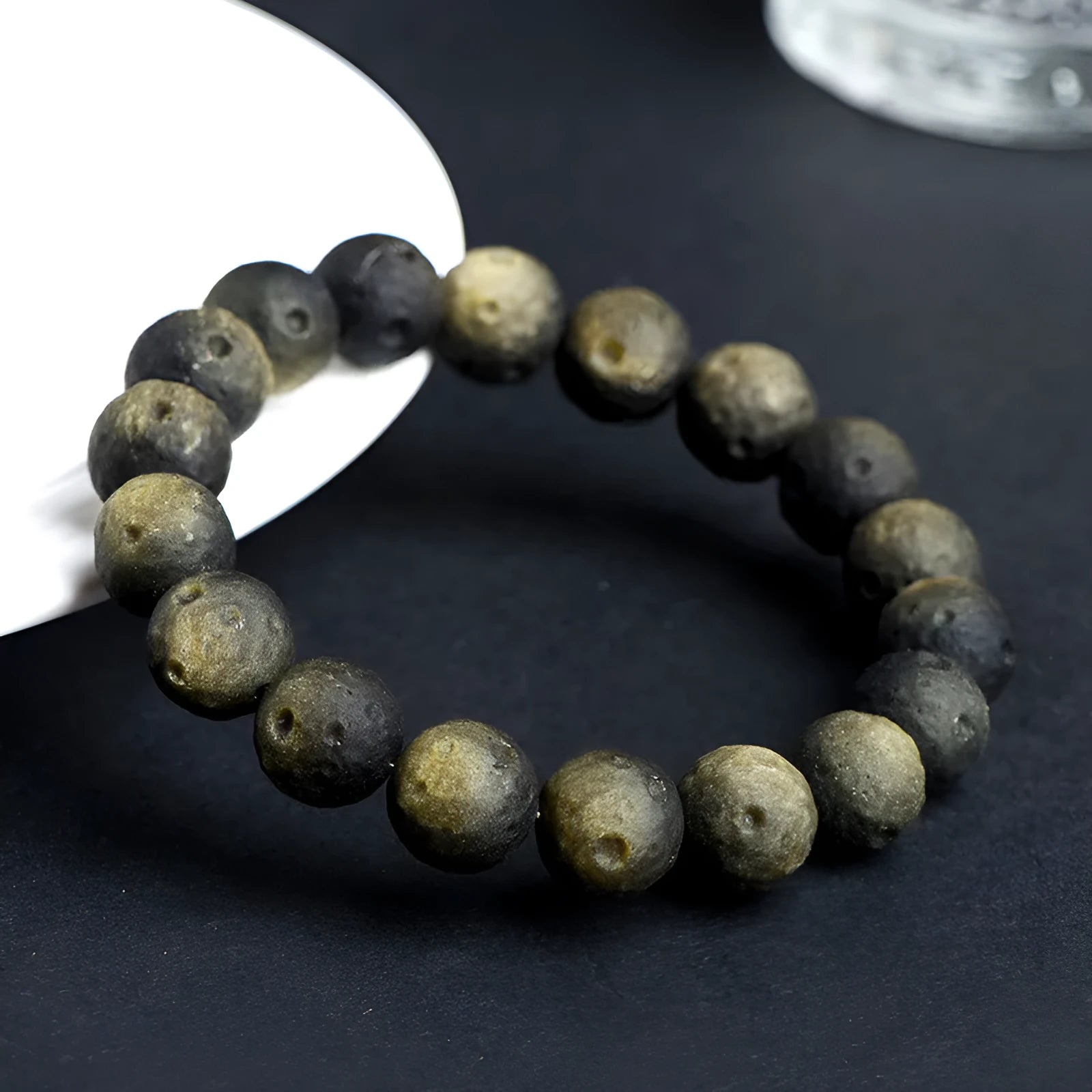 Natural obsidian crater ball bracelet showing distinctive grinding texture on beads