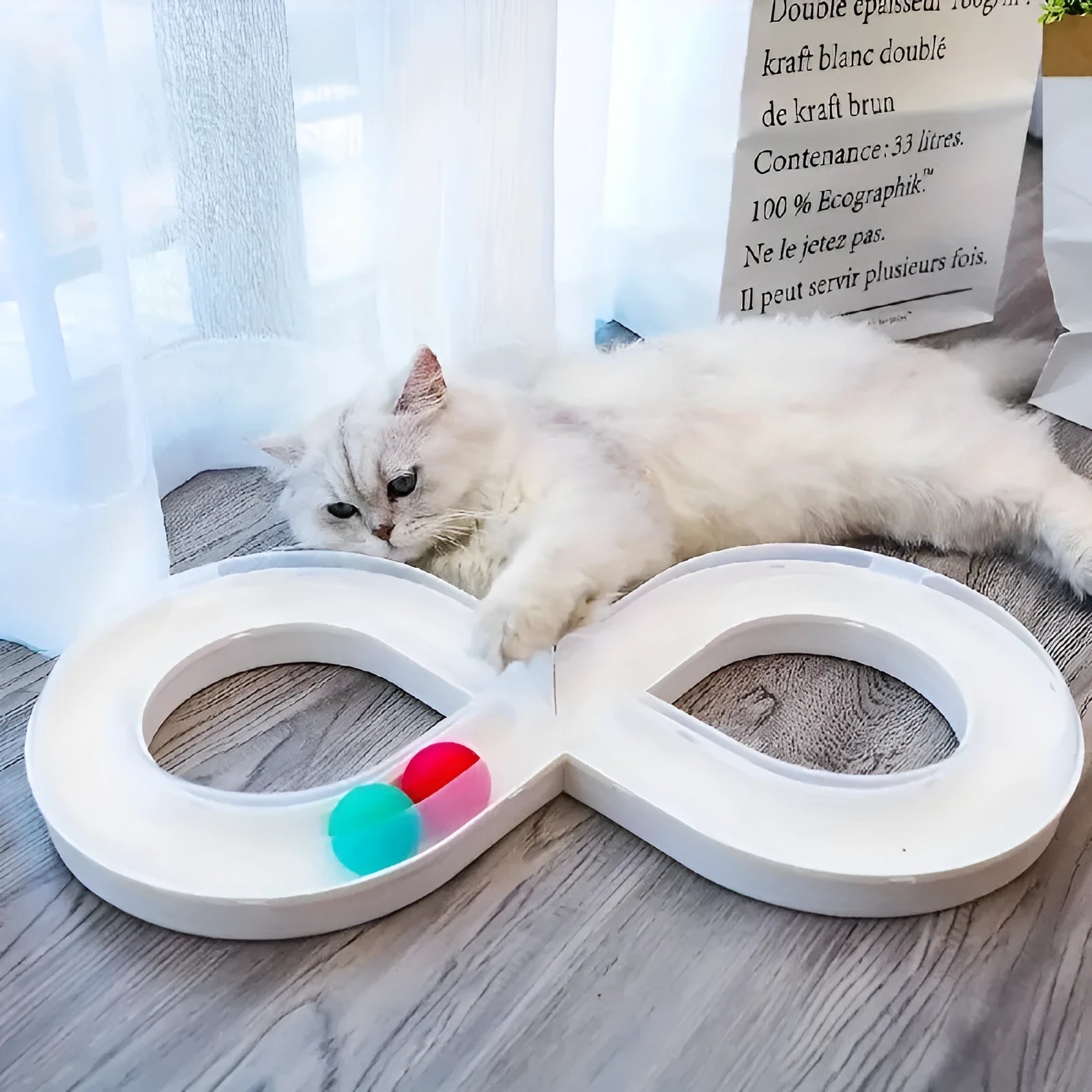 Blue and white cat turntable track ball toy with teasing stick attachment on flat surface