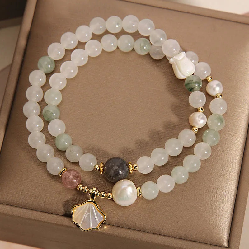 Women's emerald green crystal bracelet with gold ginkgo leaf pendant and rhinestone accents