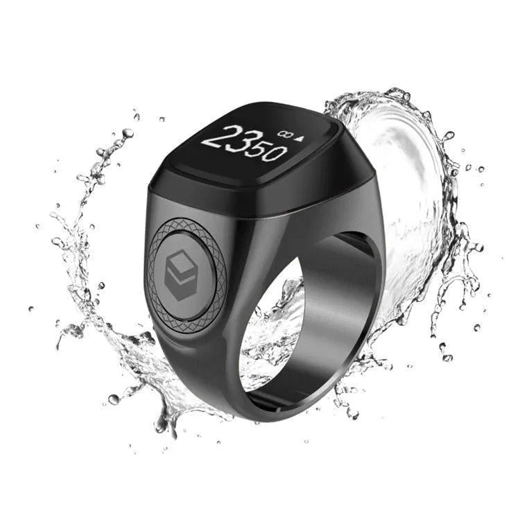 Zikr1 smart ring in silver showing OLED display with Tasbih count, next to charging case.