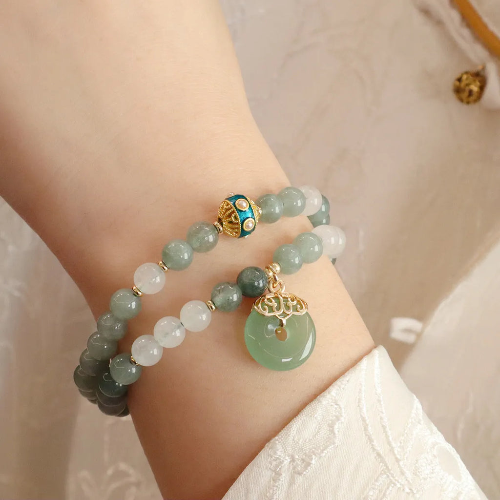Women's bracelet with a Myanmar jade safety buckle pendant and lucky beads on a geometric crystal band.