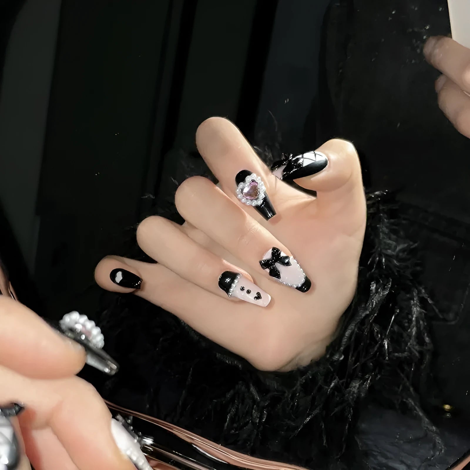 Hand-painted black and pink peach heart design on a detachable plastic manicure set with Bow and XINGX patterns.