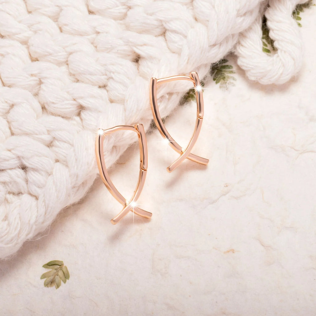 Rose gold cross shaped earrings made from copper with geometric design