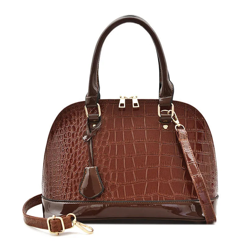 Shiny PU leather crossbody bag in shell shape design showing black, red and brown colour options
