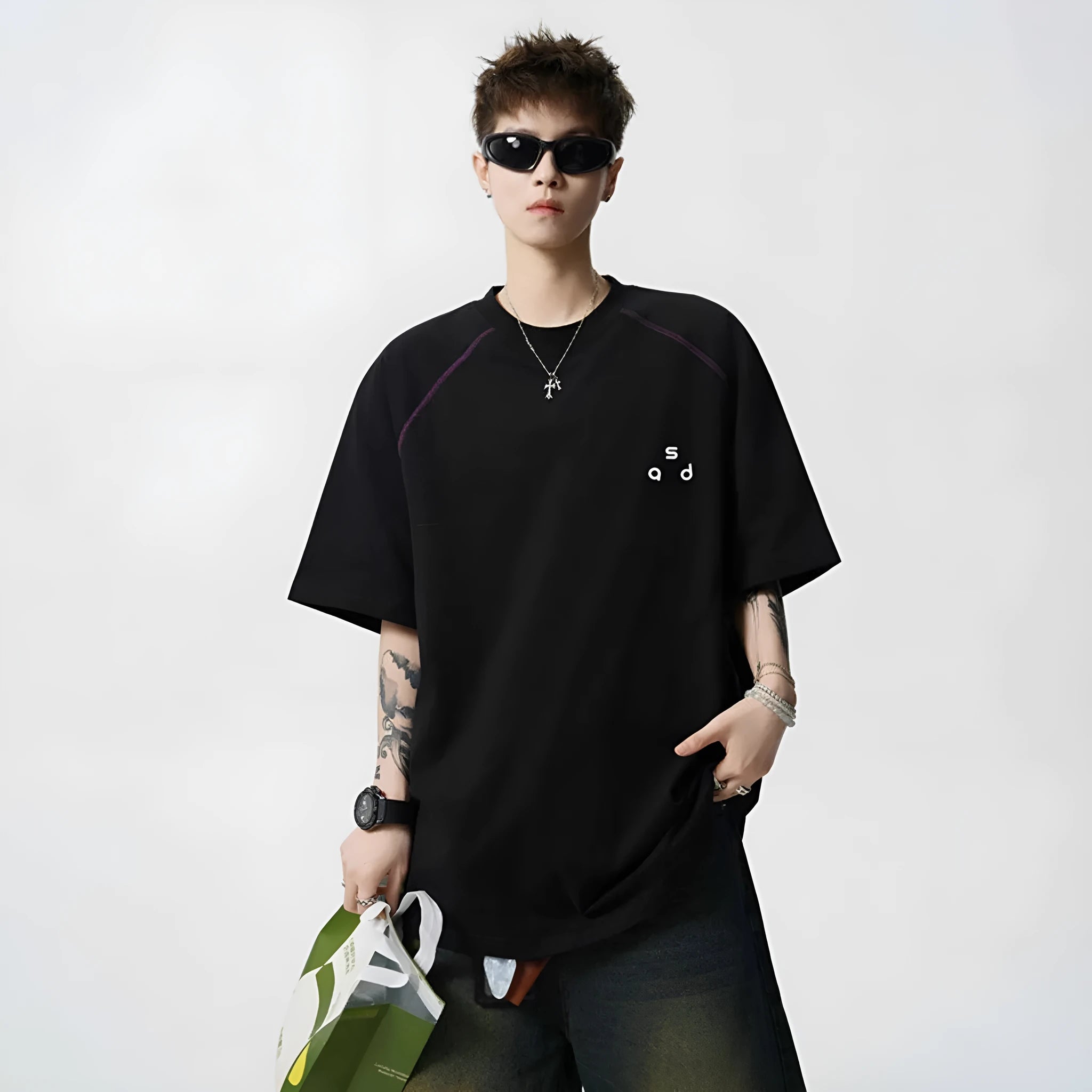 Man wearing a loose fit black cotton t-shirt with a letter print on the chest.