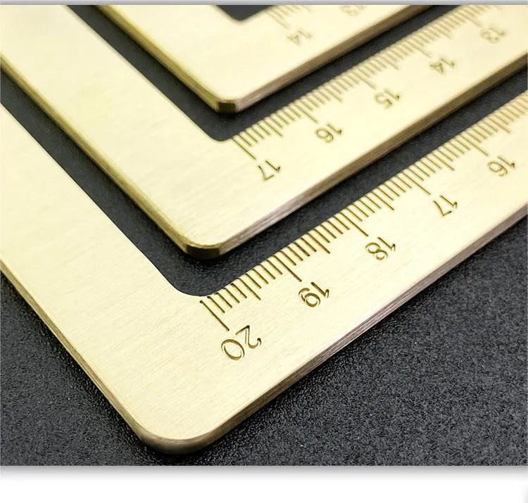 Solid brass square calligraphy paper weight with engraved design on a wooden desk.