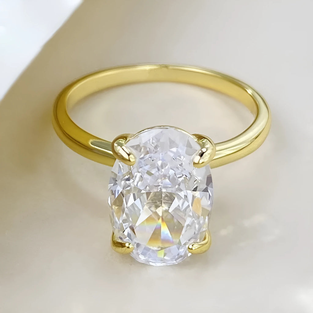 Women's oval 9K silver ring with a four-prong setting, shown in gold and silver tone finishes.