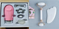 White jade facial roller and gua sha board set on a plain surface.