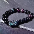 Natural ice colour obsidian crystal bracelet with spherical beads on a neutral background.