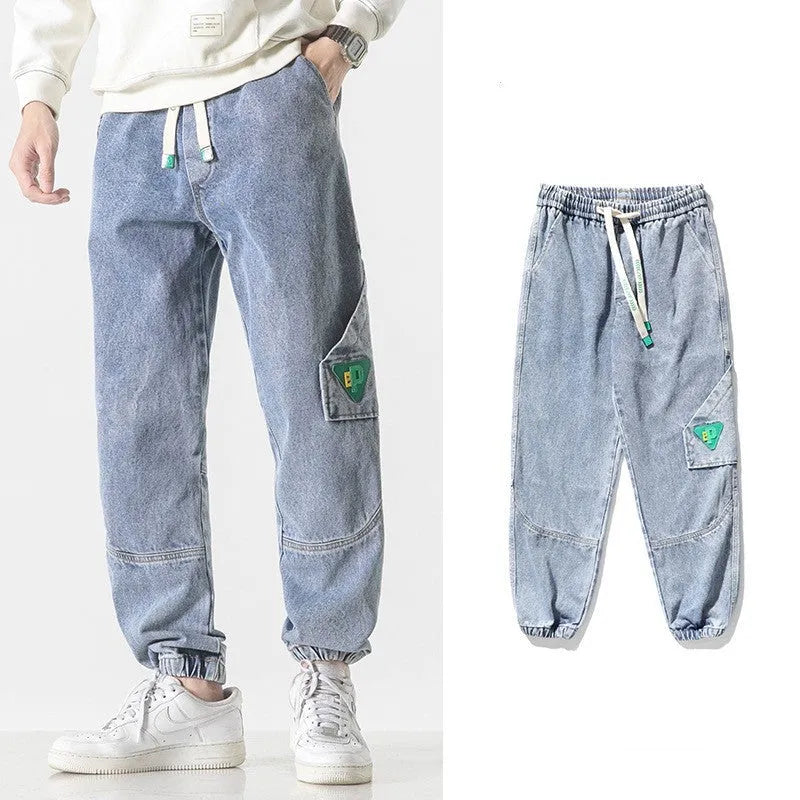 Men's loose-fit tapered cotton trousers in black, blue, or grey on a mid-waist.