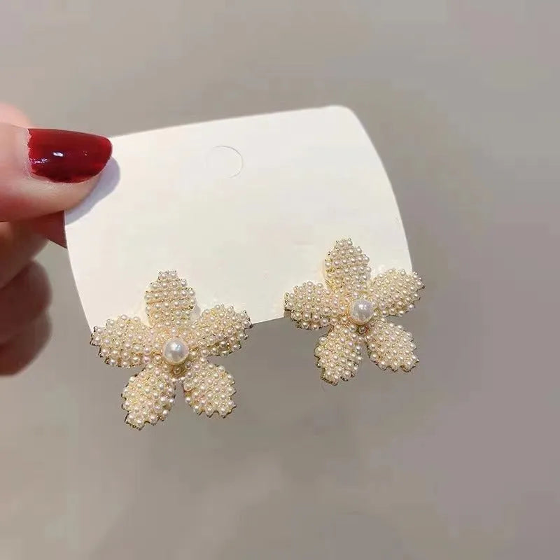 Gold colour Korean-style drop earrings featuring a pineapple and starfish design with pearl and gemstone inlay.