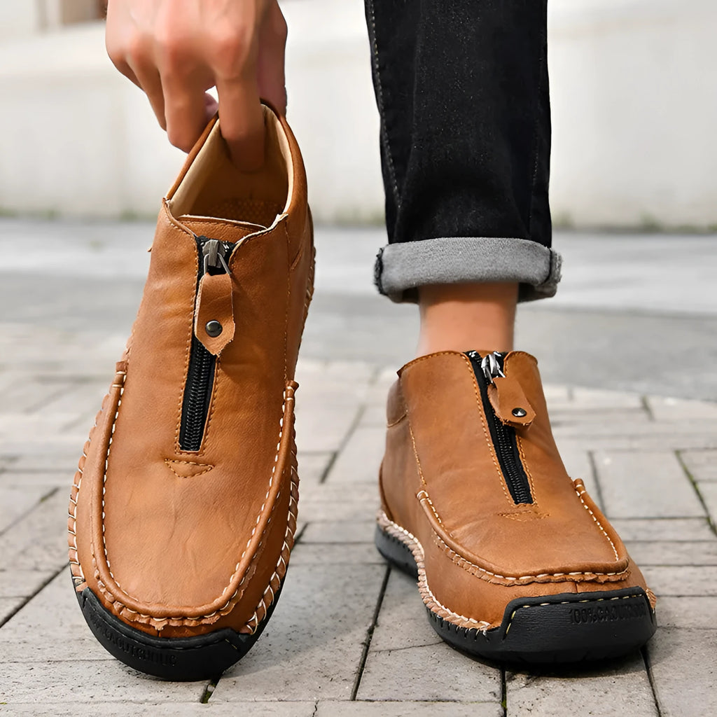 Men's black slip-on loafers with a round toe and rubber sole on a white background.