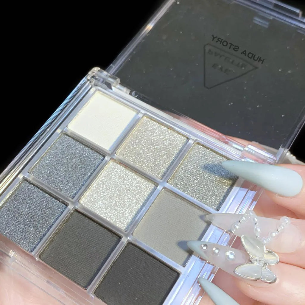Nine-colour smoked eyeshadow palette showing white, silver, black and iron grey shades in compact case