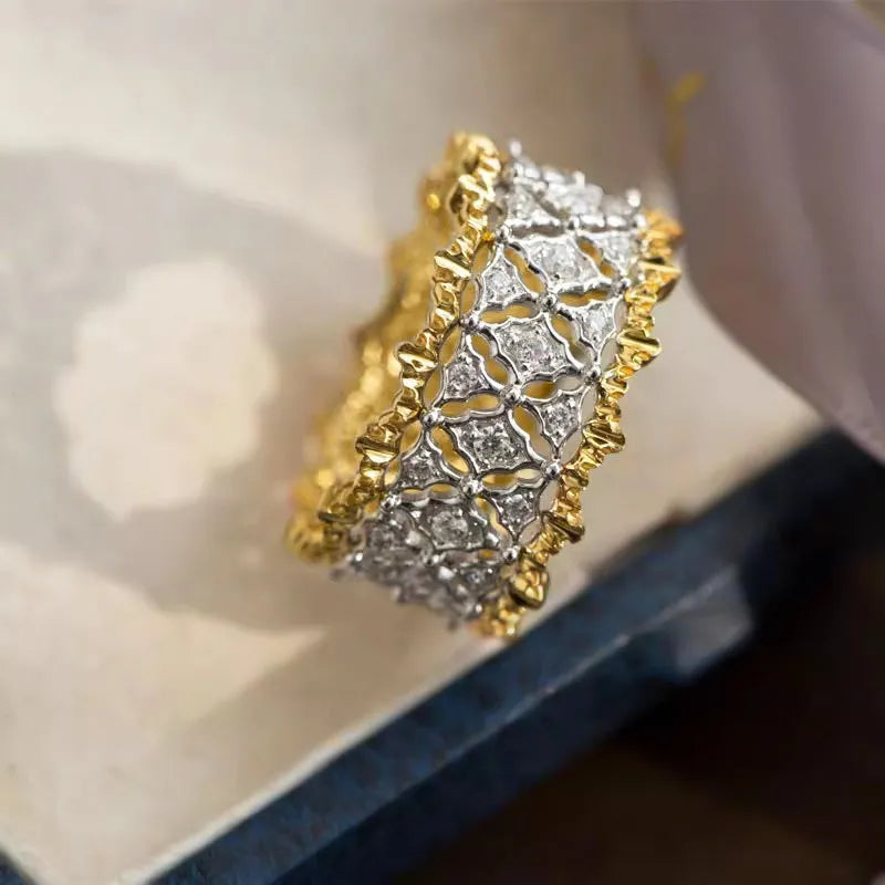 Geometric gold two-tone women's ring with round cubic zirconia stone on copper base.