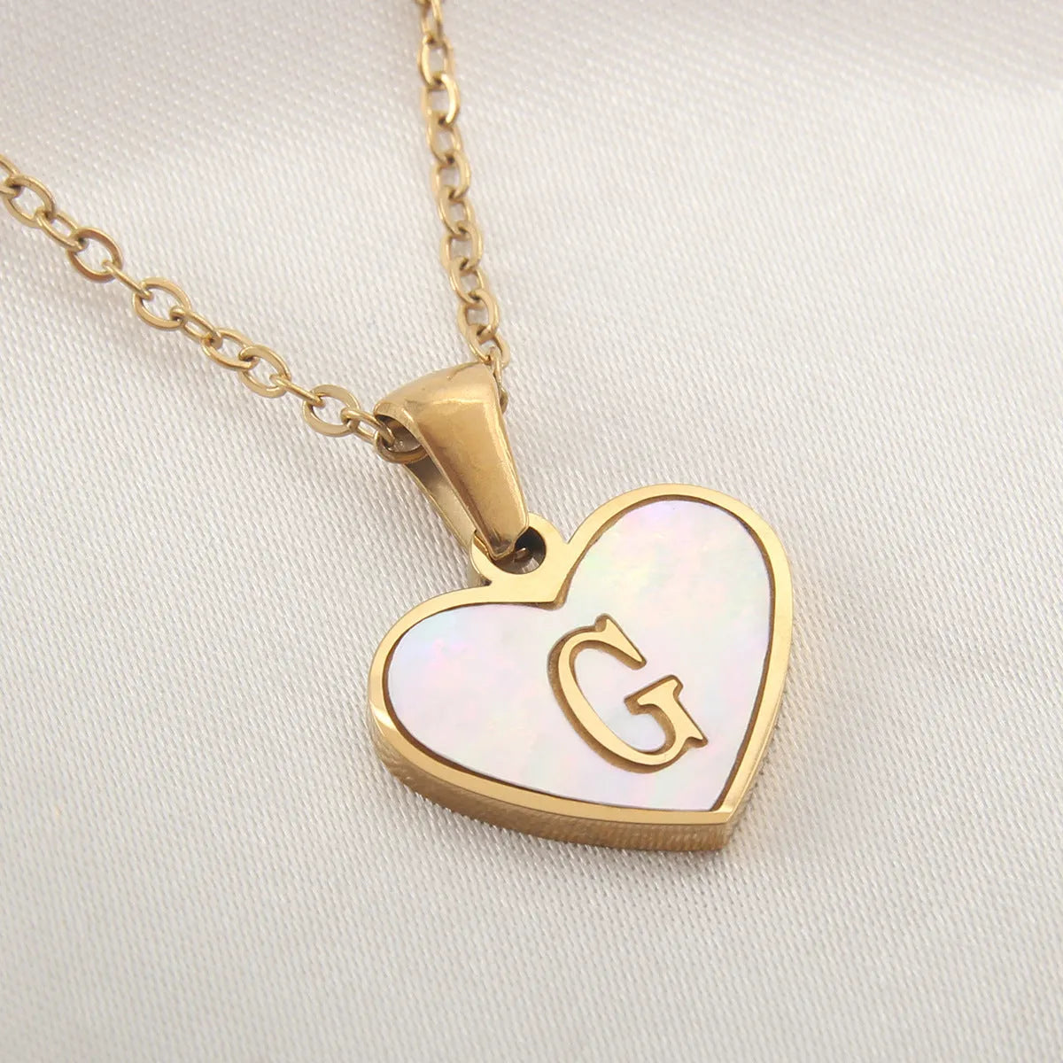 Gold plated initial necklace with white shell heart pendant and adjustable chain