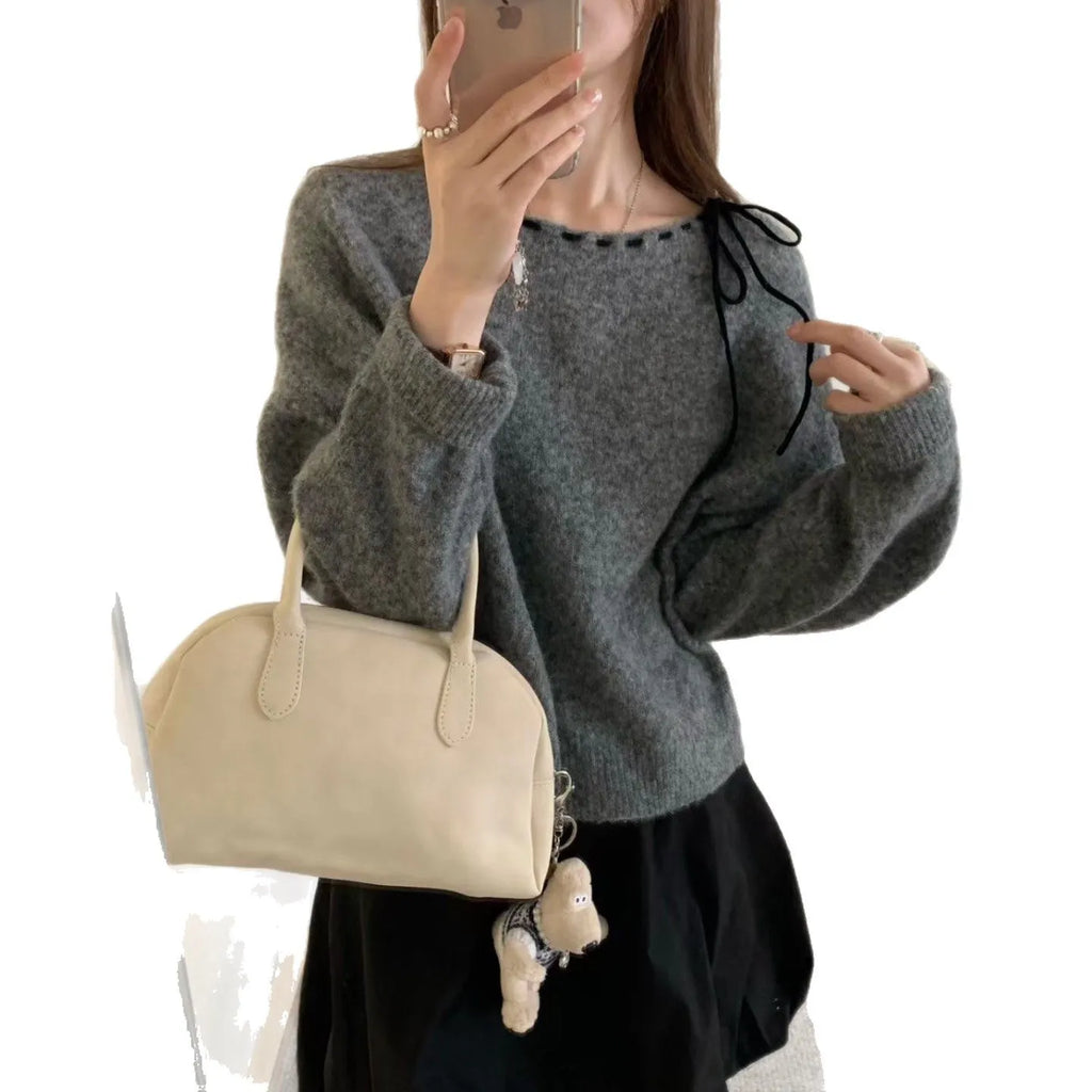 Women's loose-fitting black knitwear pullover jumper on a hanger.