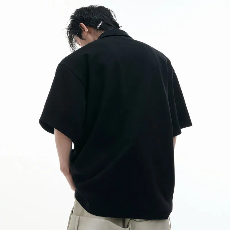 Men's black loose fit polo shirt with geometric pattern and a shirt collar.