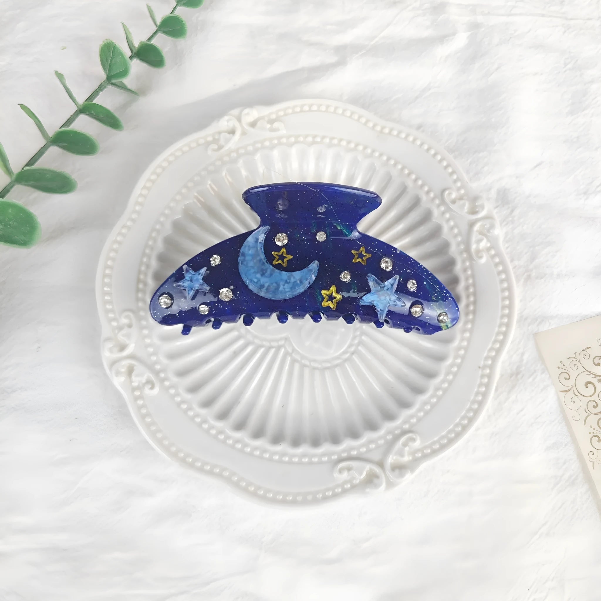 Oversized women's barrette with blue star moon starry sky pattern on a cellulose acetate clip.