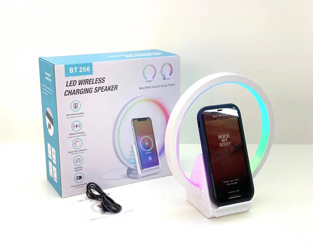 White smart Bluetooth speaker with integrated ambient lighting and a 15W wireless charging pad on top.