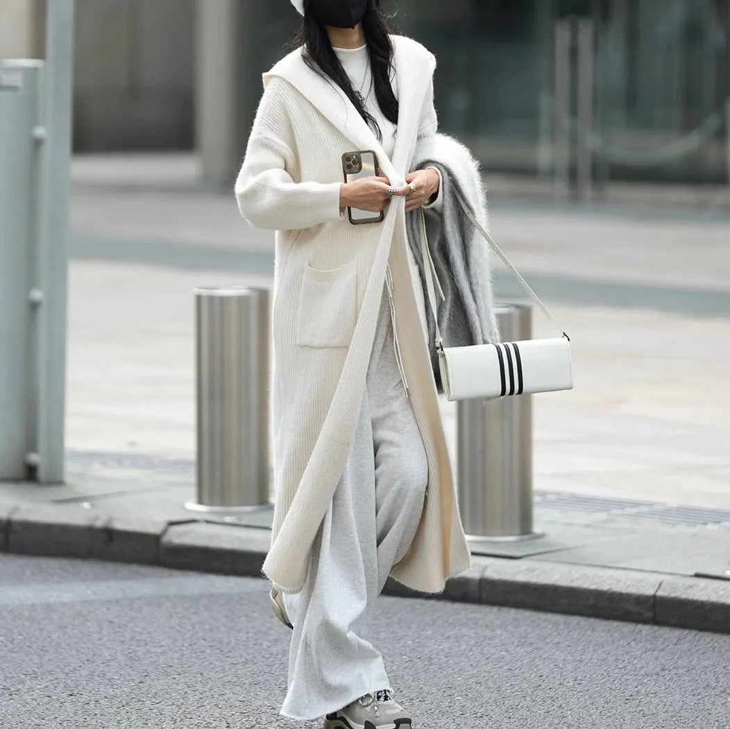 Long grey knitted hooded cardigan coat with a loose fit, shown worn open.