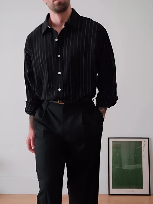 Black pinstriped button-down polyester shirt with a regular fit on a hanger.