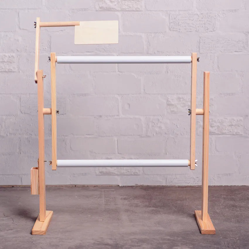 Vertical pine wood embroidery frame with height adjustment on desktop