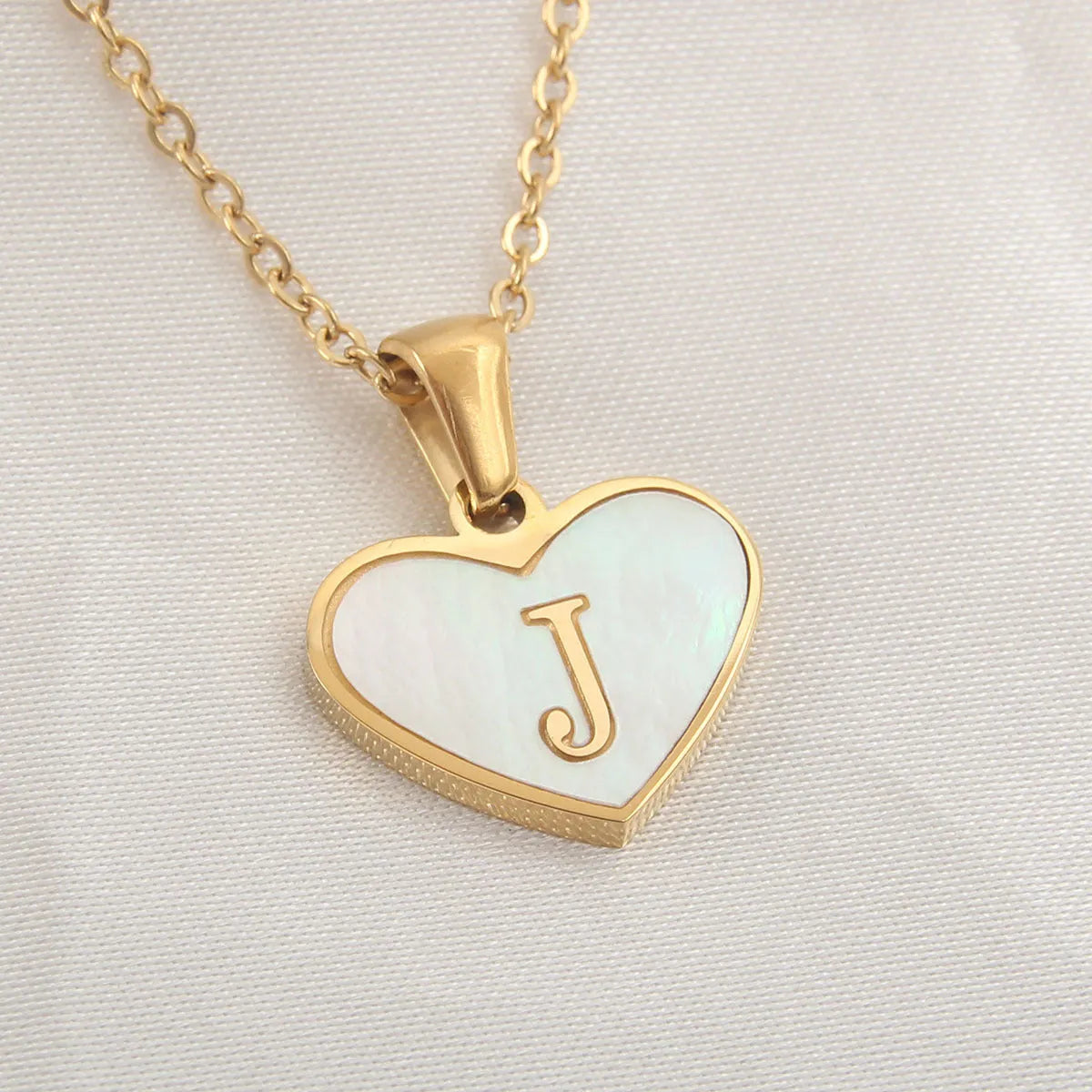 Gold plated initial necklace with white shell heart pendant and adjustable chain