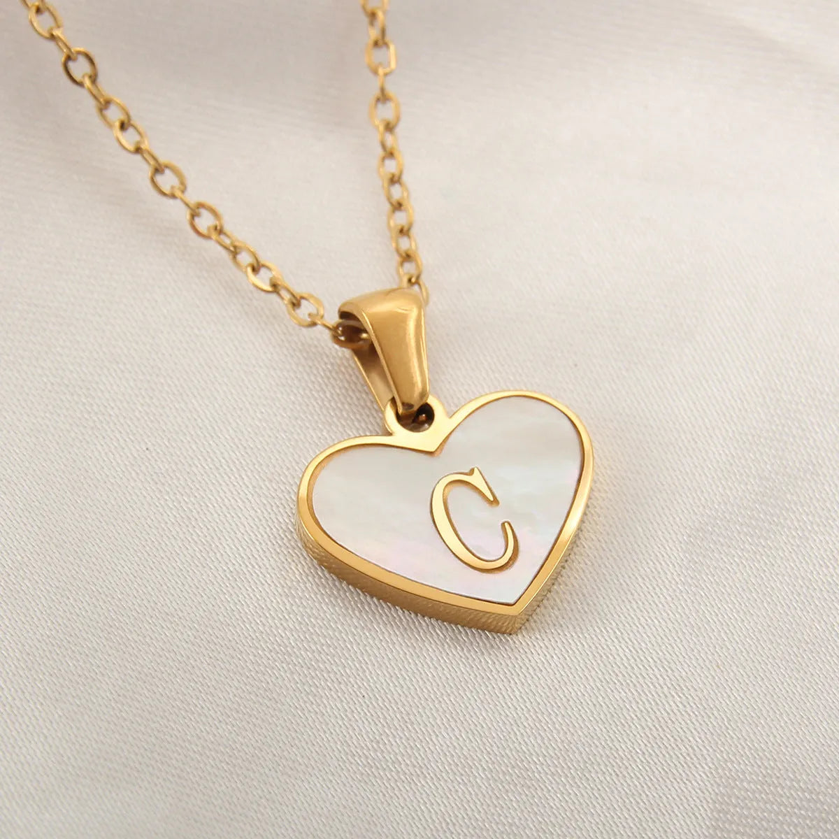 Gold plated initial necklace with white shell heart pendant and adjustable chain