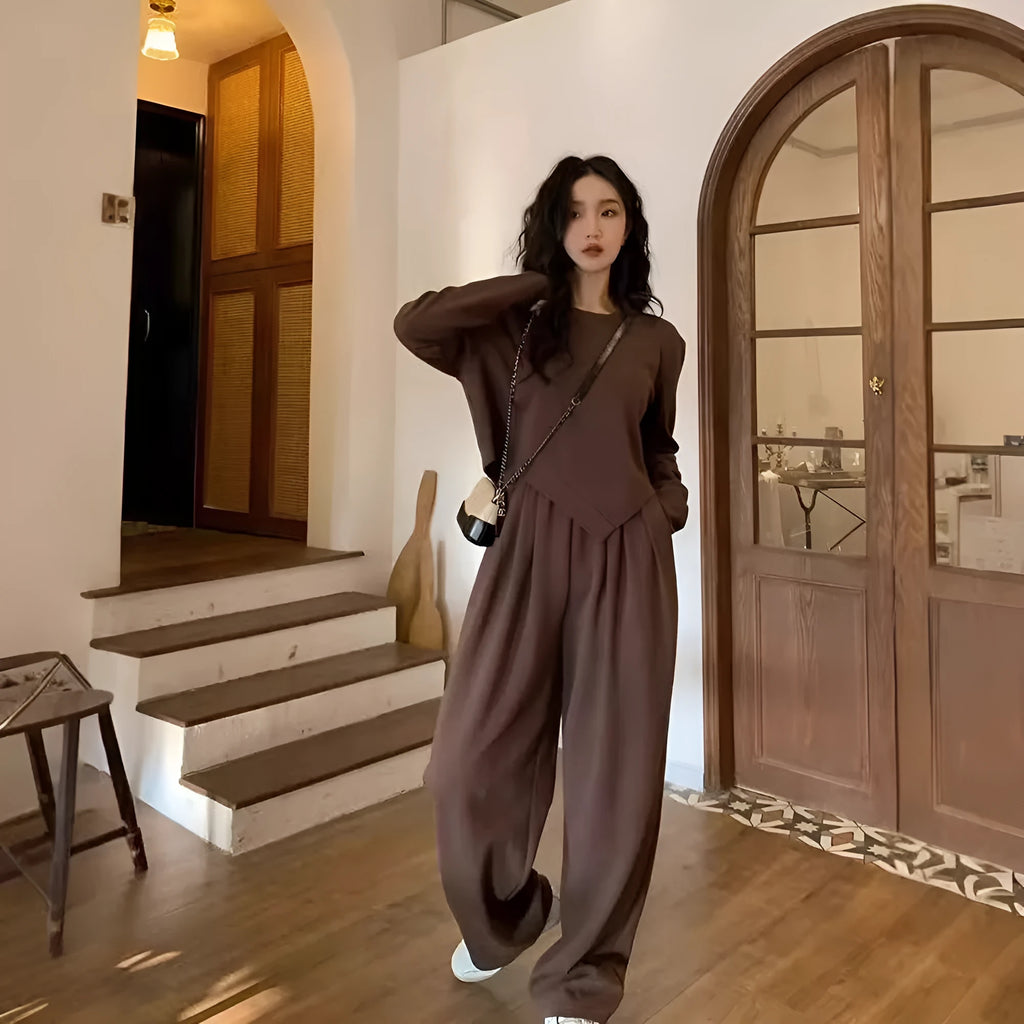 Women's brown loose-fit casual sports suit with long sleeves and full-length trousers on a hanger.