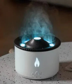 Volcanic-shaped humidifier emitting a two-colour mist from its spray ring on a table.