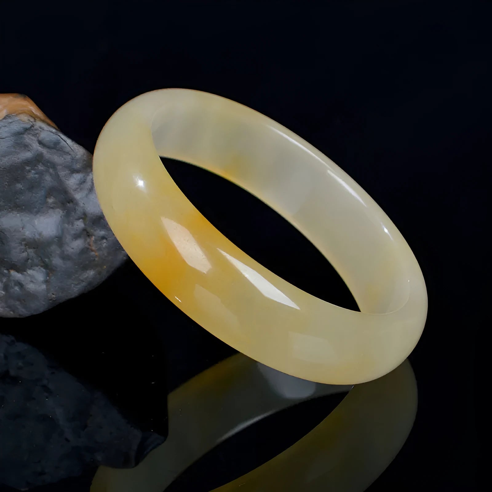 Natural light jade bracelet with a polished finish on a wrist, showing its Chinese style.