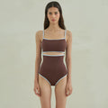 Brown women's one-piece swimsuit with triangle neckline on a hanger.