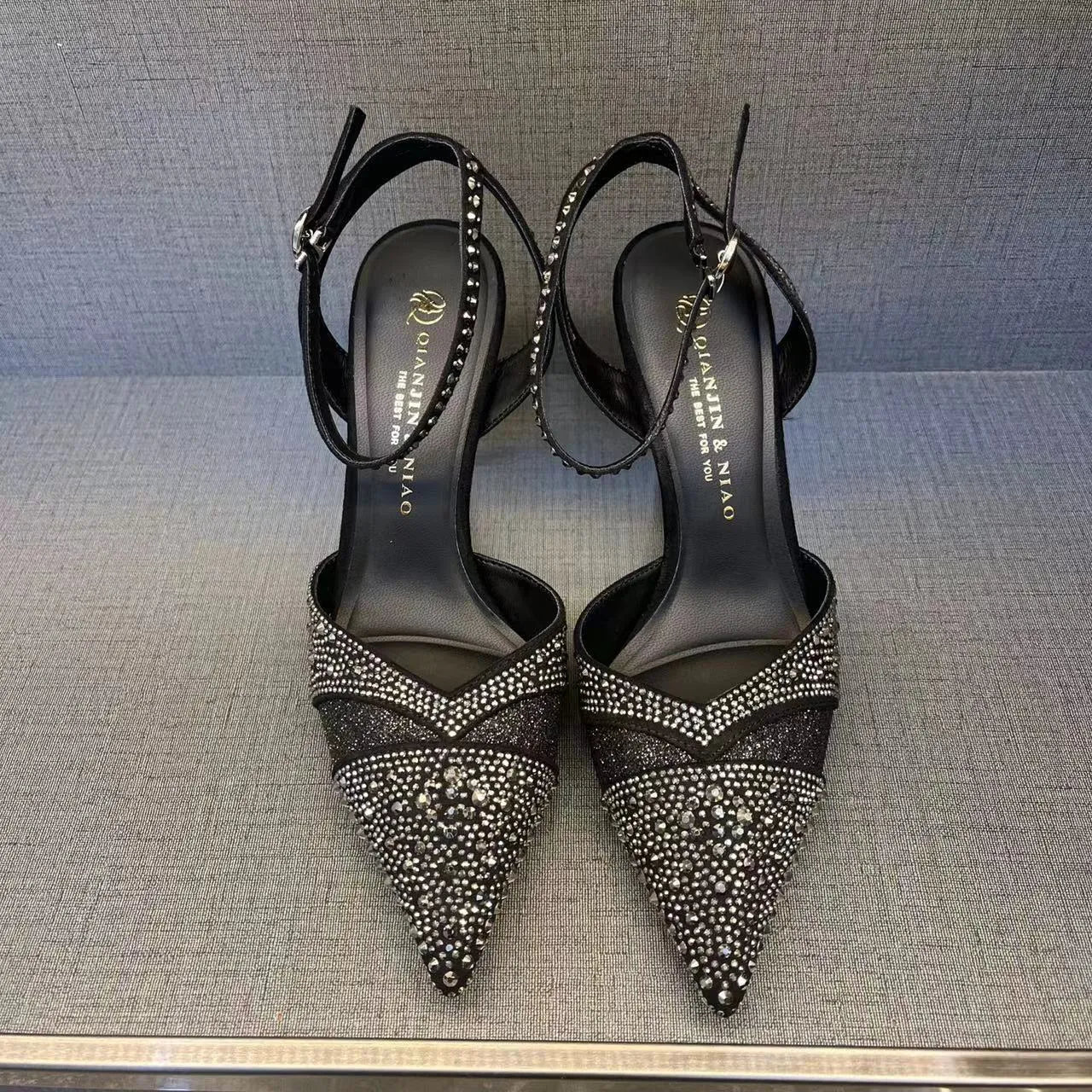 Women's black stiletto heels with pointed toe, hollowed design and red sole
