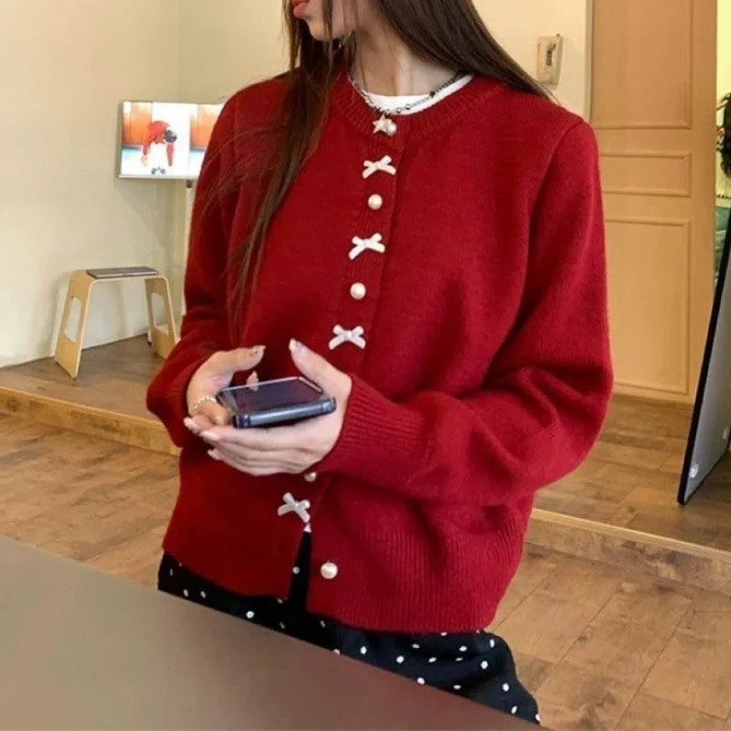 Women's light blue cardigan sweater with white bow pearl buttons fastened.