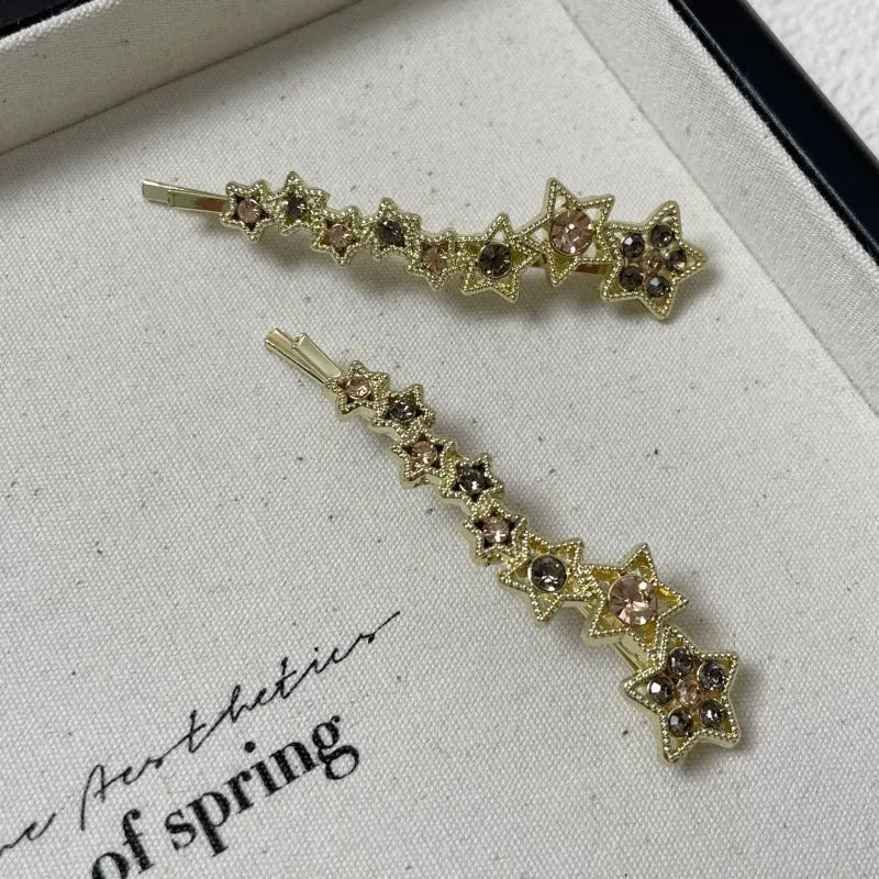 Gold electroplated rhinestone barrette with star design and side clip for bangs