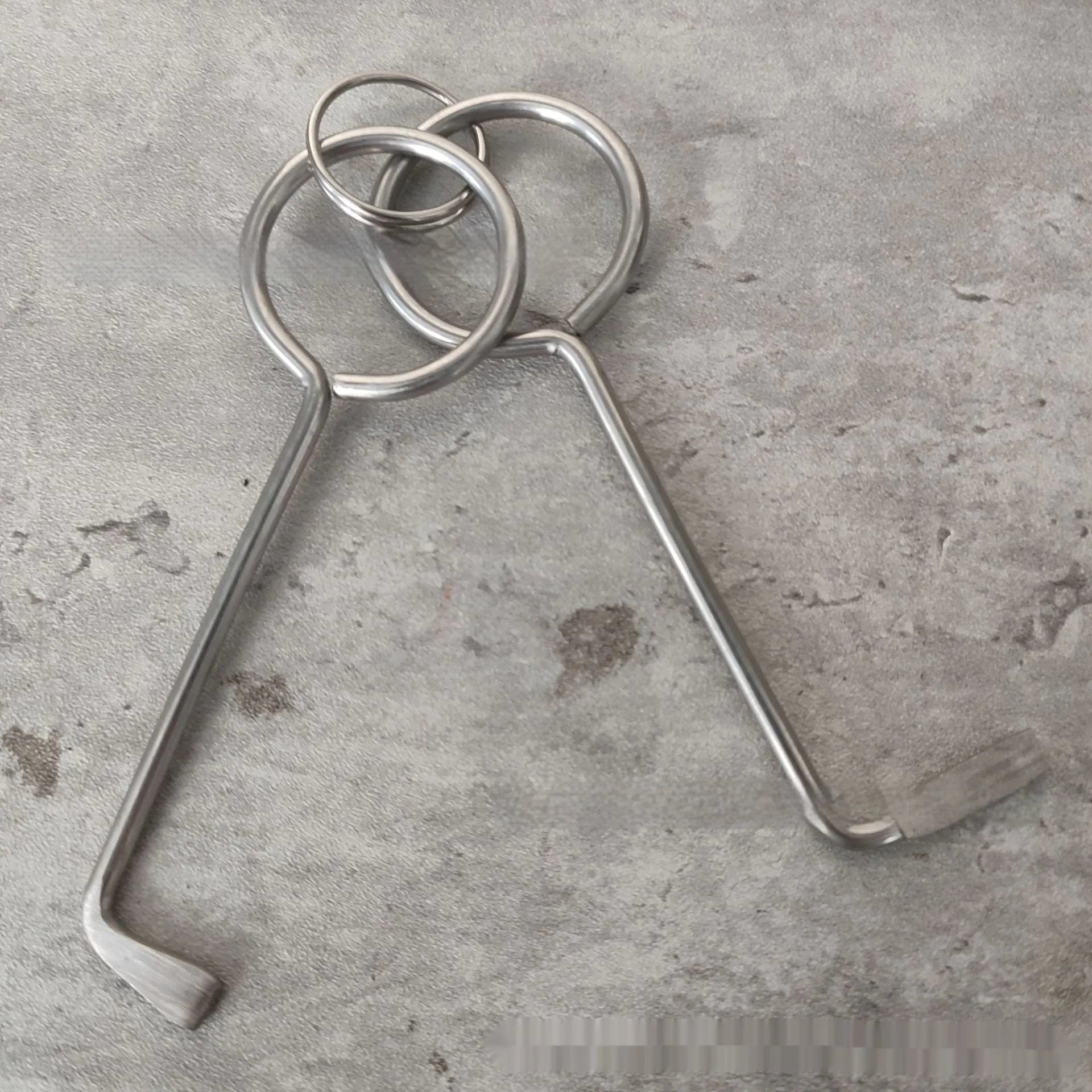 Two alloy wrench tools from a portable family maintenance set on a plain background.