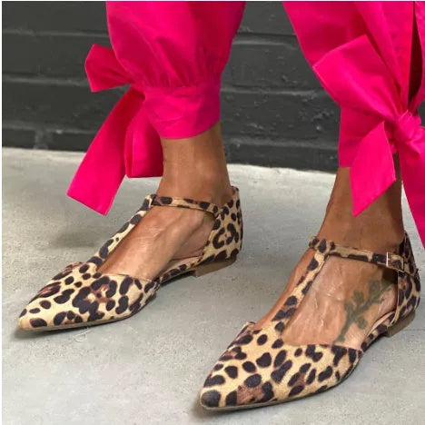 Leopard print women's pumps with pointed toe, cross straps, and a chunky low heel.