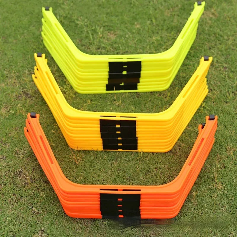 Set of six foldable yellow green and orange hexagon plastic agility training rings laid out on grass