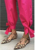 Leopard print women's pumps with pointed toe, cross straps, and a chunky low heel.