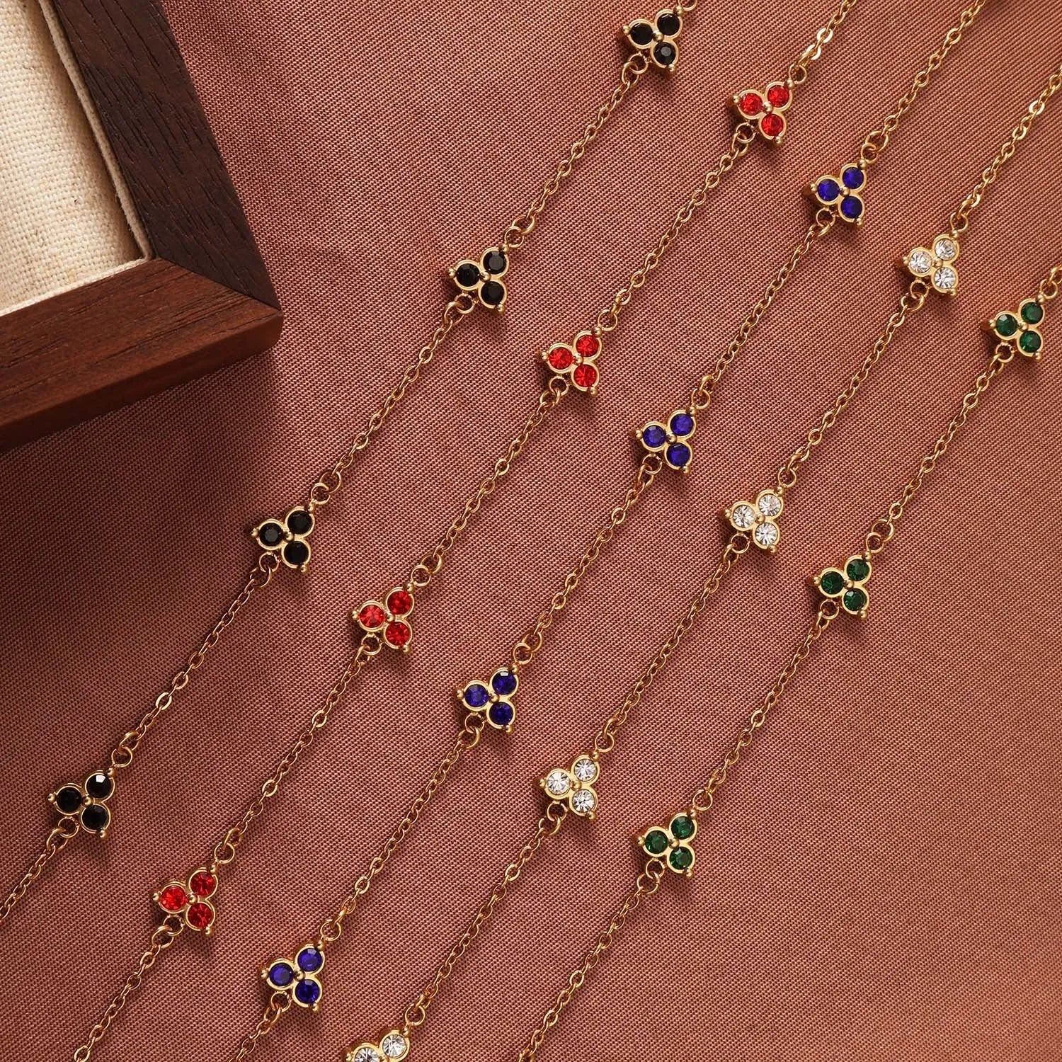 Geometric triangle bracelet for women in stainless steel with coloured zircon stones.