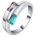 Silver-coloured electroplated copper ring with a zircon stone inlay on a finger.