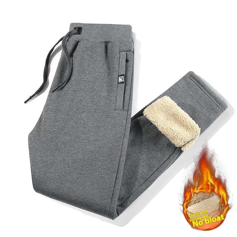 Men's grey fleece-lined oversized track pants with elastic waistband on hanger