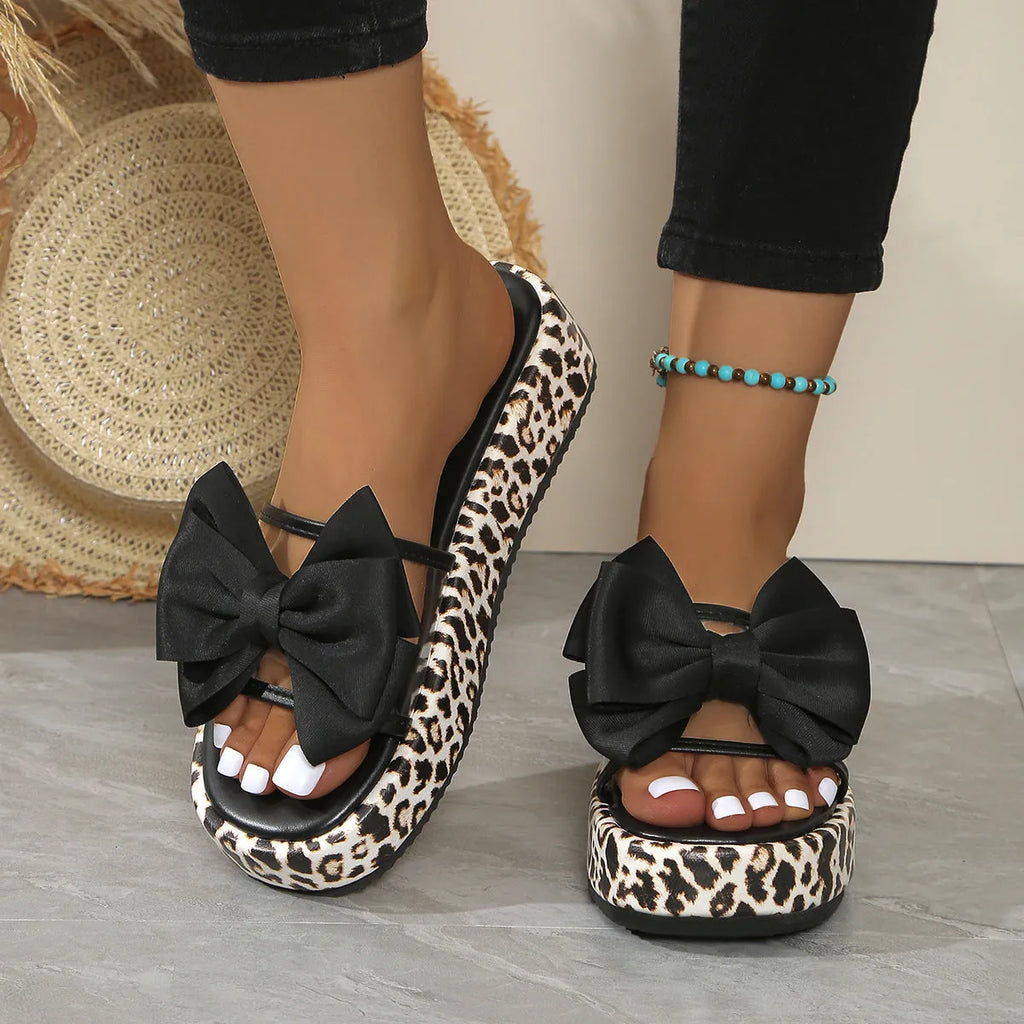 Women's white and black leopard print beach slippers with thick sole and round toe.