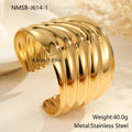 Gold-plated stainless steel bracelet with asymmetric geometric wave design and wide opening.