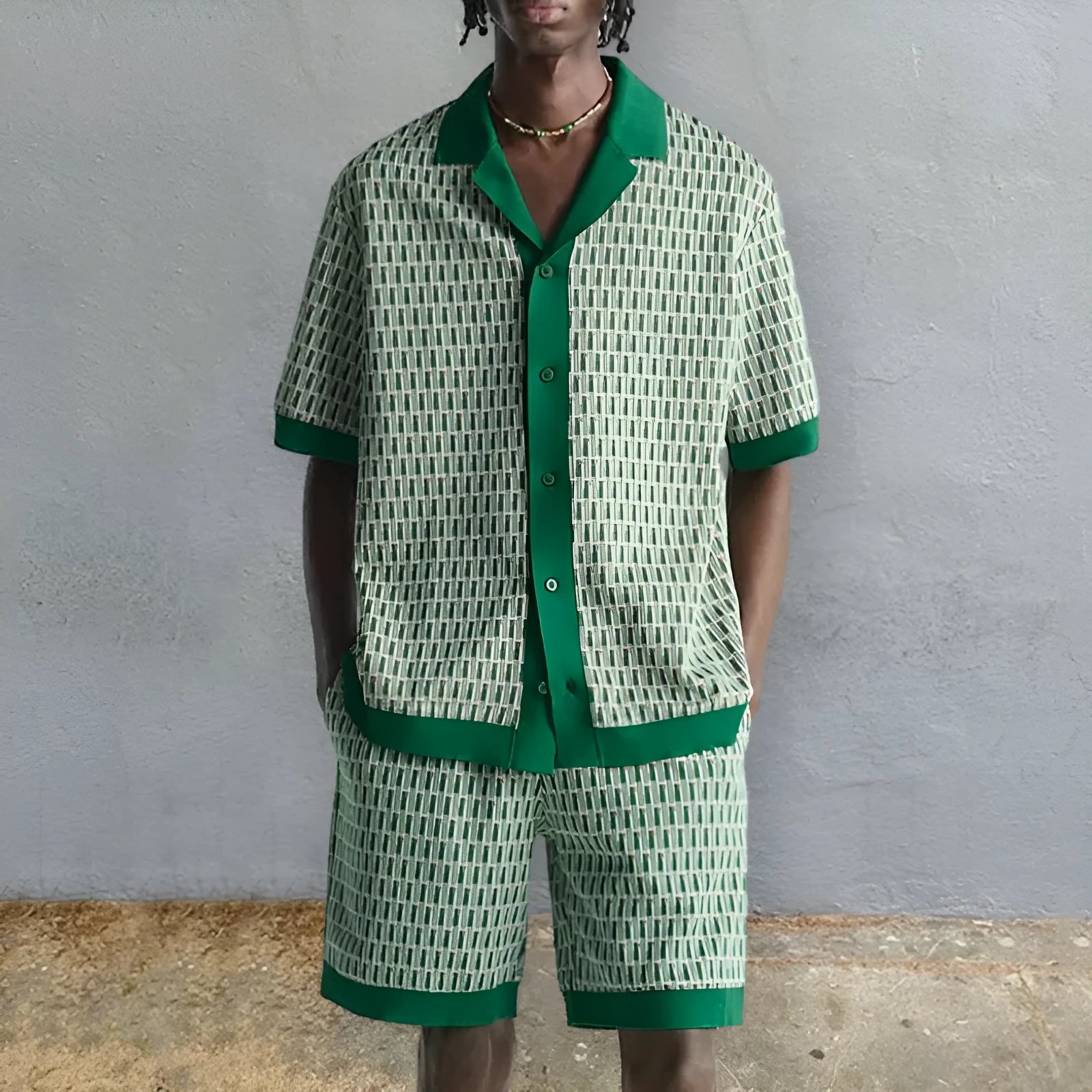 Man modelling a light blue printed short-sleeved shirt and matching elastic shorts from a beachwear two-piece set.