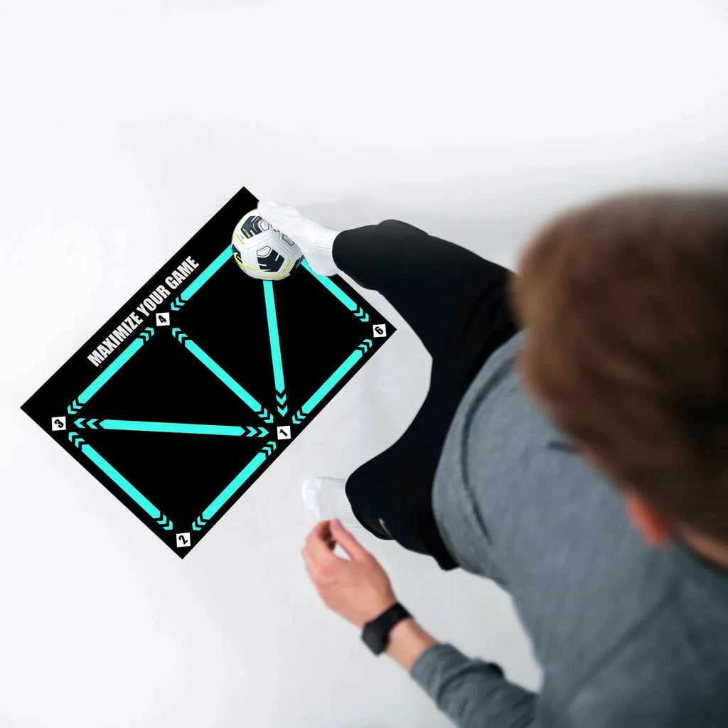Large black rectangular rubber football training mat measuring 60x90 cm on a floor.