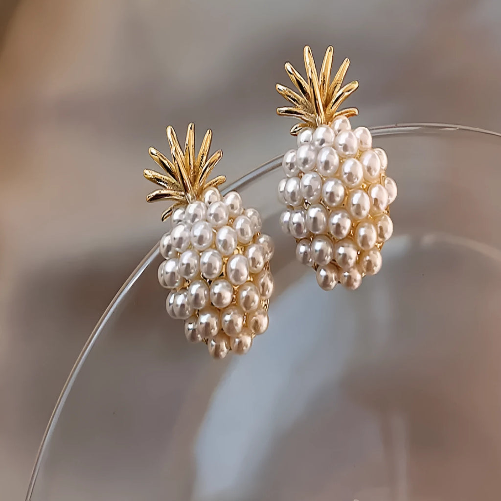 Gold colour Korean-style drop earrings featuring a pineapple and starfish design with pearl and gemstone inlay.