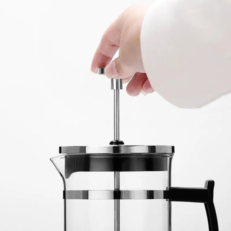 Compact glass stovetop coffee maker with stainless steel components, shown with dimensions 10cm wide and 17cm high.