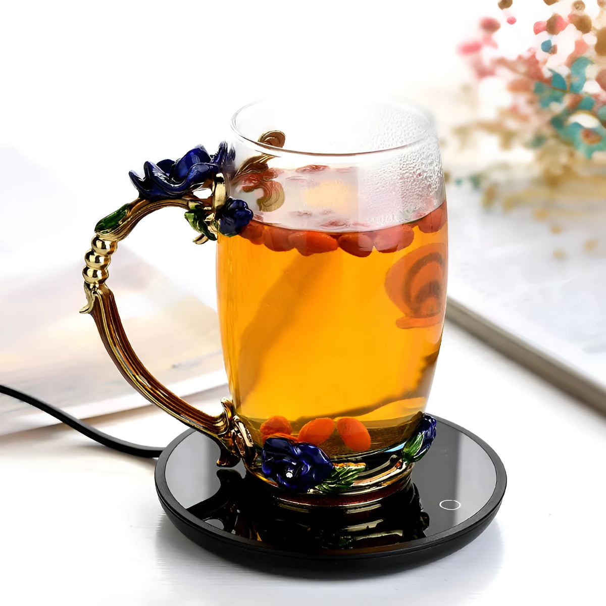 Black circular coffee cup warmer with low and high temperature switch on a desk