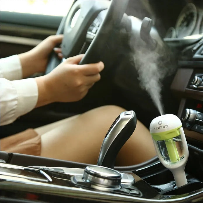 Blue portable car humidifier and air freshener diffuser with rotation nozzle on a car dashboard